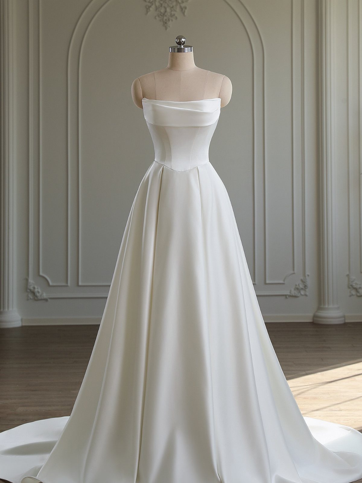 Strapless white satin A-line wedding gown on a mannequin in a bright room