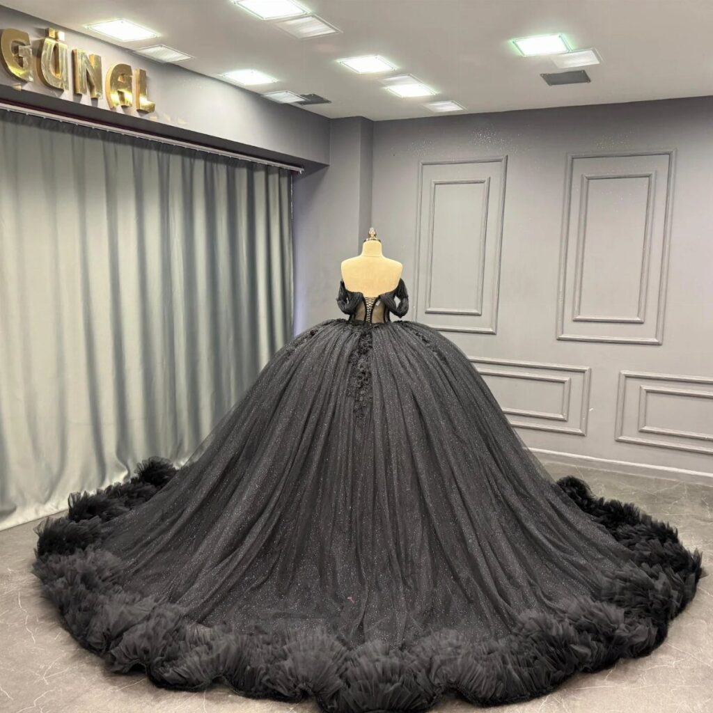 Black ballgown wedding dress with sparkling fabric and long train on a mannequin