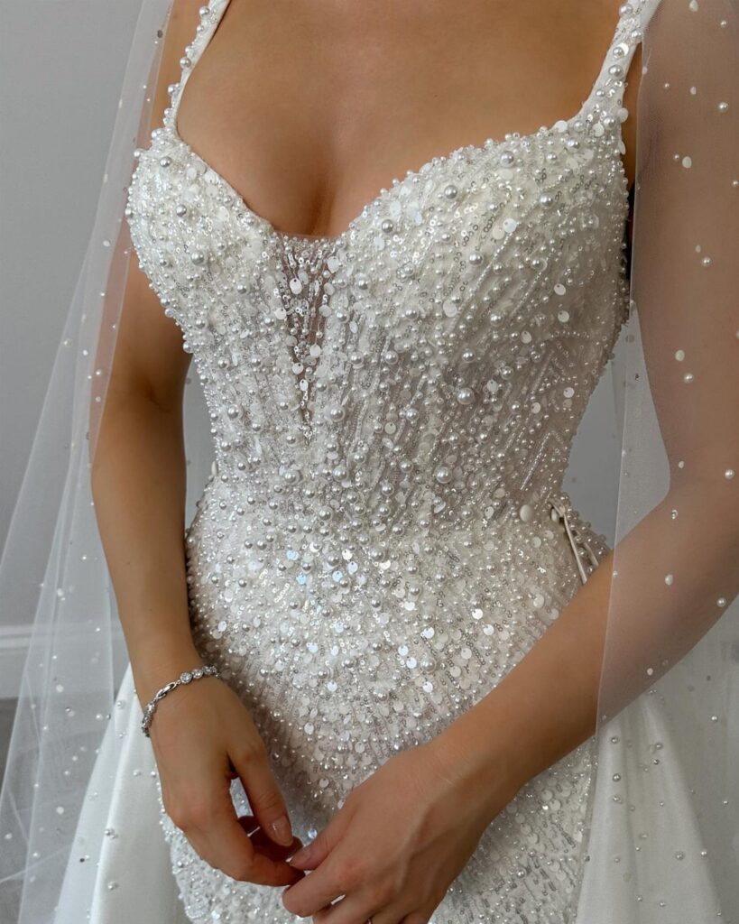 Beaded white wedding dress with sequins and pearls and a matching sheer veil