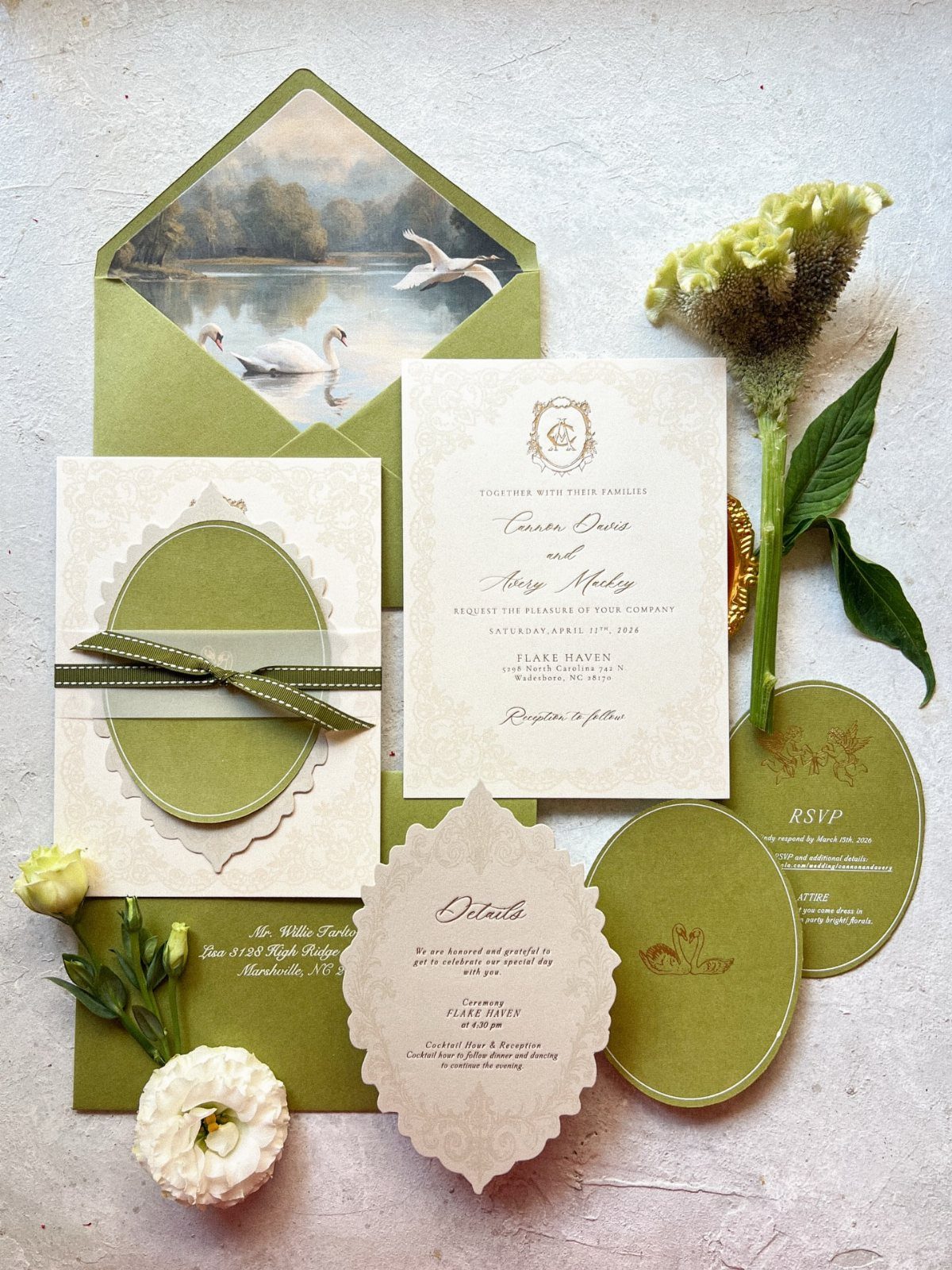 Wedding invitation suite in sage green and cream with floral accents and swan envelope.